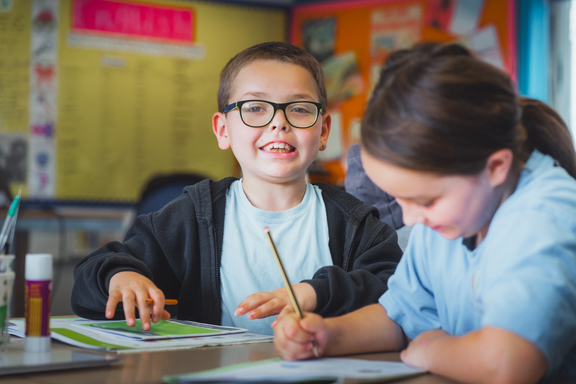 student smiling to camera at table